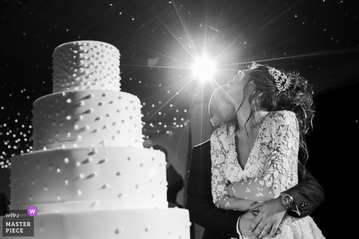 Photo by: <a href="https://www.wpja.com/contests/2018-v06-photography-competition/best-wedding-photographers/2209691">Daniele Borghello - Padova</a> Photo of bride and groom hugging in front of the wedding cake at Como Lake, Italy