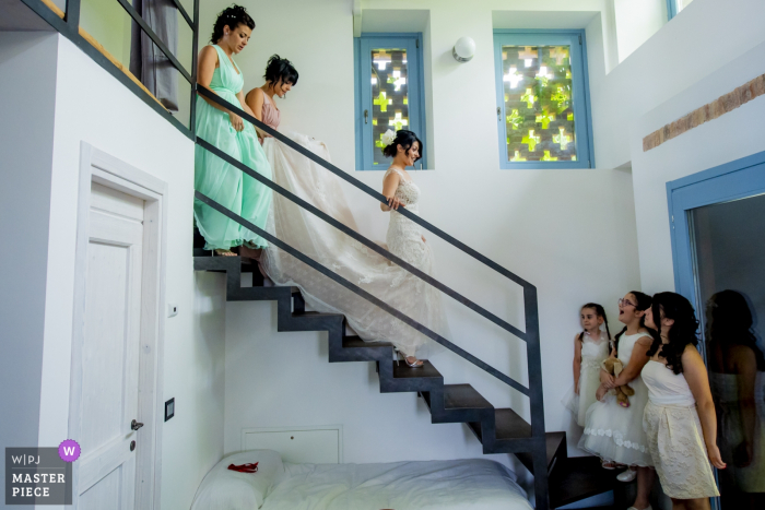 Foto door: <a href="https://www.wpja.com/contests/2018-v06-photography-competition/best-wedding-photographers/2210861"> Luigi Rota - Comomeer Lecco </a> Bruid loopt de trap af met haar bruidsmeisjes in Italië