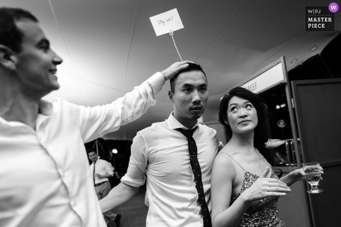 Photo by: <a href="https://www.wpja.com/contests/2018-v06-photography-competition/best-wedding-photographers/2211871">Tanarak Visessonchoke - San Francisco California</a> Guests joking around in a black-and-white photo from the wedding reception in San Francisco