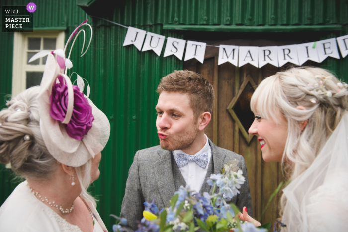 Photo by: <a href="https://www.wpja.com/contests/2018-v06-photography-competition/best-wedding-photographers/2211981">Nick Brightman - Wolverhampton West Midlands</a> Bride and groom smiling and having fun with a guest after the wedding ceremony at the Avoncroft Museum, Birmingham