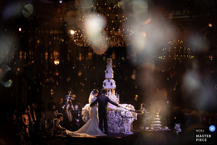 Photo by: <a href="https://www.wpja.com/contests/2018-v06-photography-competition/best-wedding-photographers/2212106">Chanarthip Cheingthong - Bangkok </a> Bangkok bride and groom are about to cut the wedding cake at the wedding reception