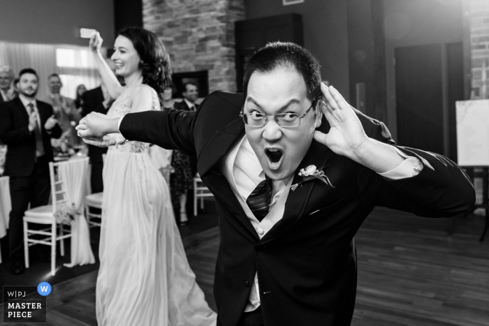 Foto: <a href="https://www.wpja.com/contests/2018-v06-Fotowettbewerb/Best-wedding-Photographier/2213531"> Esther Gibbons - Montreal Quebec </a> Auberge des Gallant, Saint-Marthe, Quebec Schwarz-Weiß-Hochzeitsfoto des Bräutigams, das die Gäste ermutigt, lauter zu werden