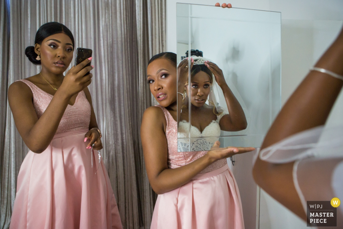 Photo by: <a href="https://www.wpja.com/contests/2018-v06-photography-competition/best-wedding-photographers/2214631">Obi Nwokedi - London London</a> Picture of London bride looking in the mirror with the help of her bridesmaids