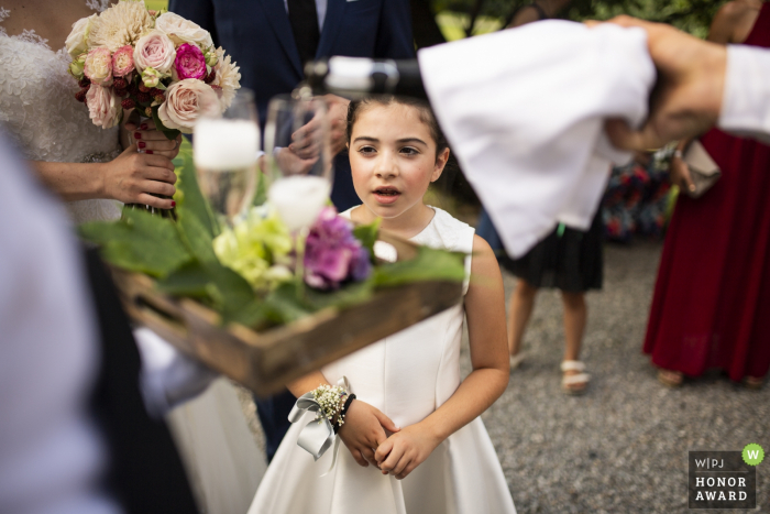 Foto door: <a href="https://www.wpja.com/contests/2018-v07-photography-competition/best-wedding-photographers/2227176"> Luigi Rota - Comomeer Lecco </a> Het de bloemmeisje van Italië let op iedereen bij de huwelijksontvangst
