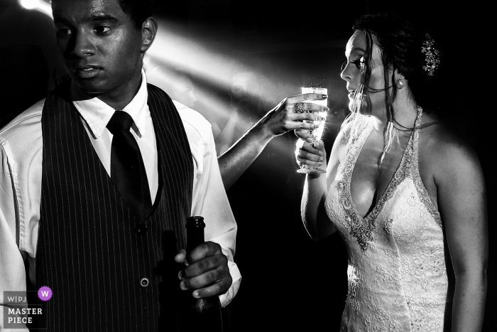 Bride and groom holding their drinks at the wedding reception in Goiânia