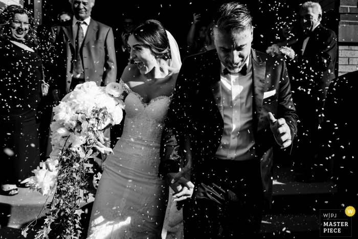The bride and groom are showered with rice as they exit the ceremony St. George Greek Orthodox Church - The bride and groom are showered with rice as they exit the ceremony in Lynn Massachusetts