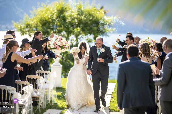 Foto door: <a href="https://www.wpja.com/contests/2018-v08/best-wedding-fotografen/2231311"> Luigi Rota - Comomeer Lecco </a> Lecco-gasten gooien rijst buiten bij de bruid en bruidegom na de huwelijksceremonie