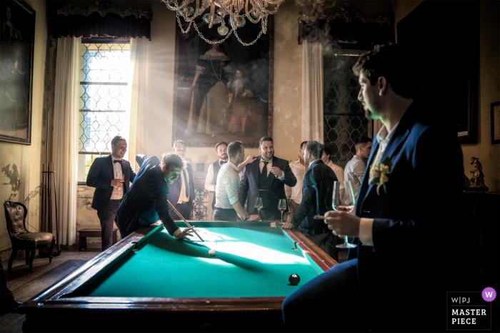 El novio de Venecia y los invitados jugando al billar antes de la boda.