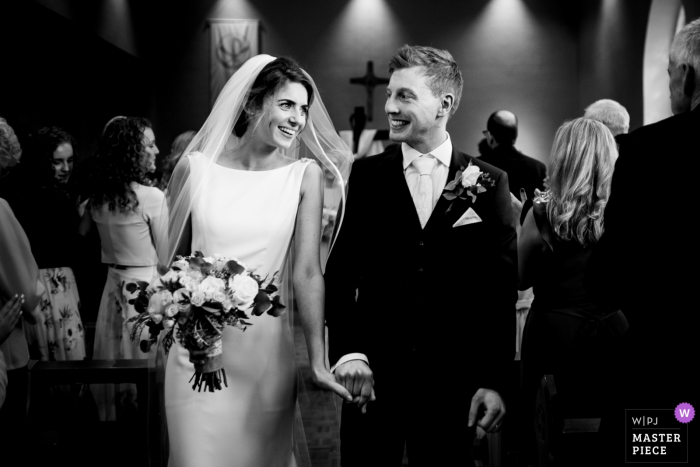 Image of the Bride and groom as they walk down the aisle after the wedding ceremony in Kildare, Ireland Bride and groom smile at each other as they walk down the aisle after the wedding ceremony in Kildare, Ireland