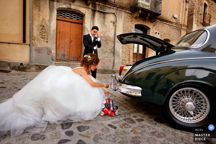 Foto door: <a href="https://www.wpja.com/contests/2018-v08/best-wedding-fotografen/2236531"> Danilo Coluccio - Siderno Reggio Calabria </a> De bruid van Calabrië buiten het vasthaken van blikken met de bruidegom op de rug van de auto na de bruiloft