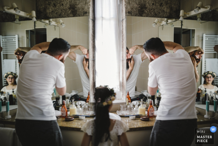 Portugal flower girl watches as the groom shaves before the wedding ceremony