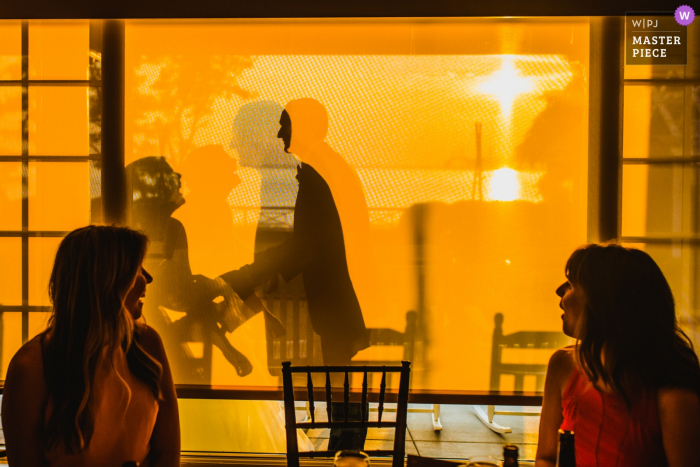 Guests watching the bride and groom through the window at the wedding reception in Stevensville, MD