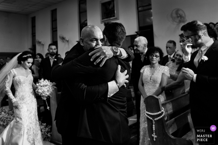 Groom hugs the brides father during the wedding ceremony in Goiânia