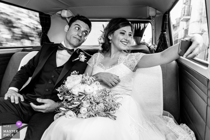 Foto: <a href="https://www.wpja.com/contests/2018-v10-Fotowettbewerb/Best-wedding-Fotografen/2250351"> Salvo Moroni - Viagrande Catania </a> Schwarzweiss-Foto der Braut, die ein selfie mit ihrem Bräutigam in einem Fahrzeug von einem Sizilien-Hochzeitsfotografen macht.