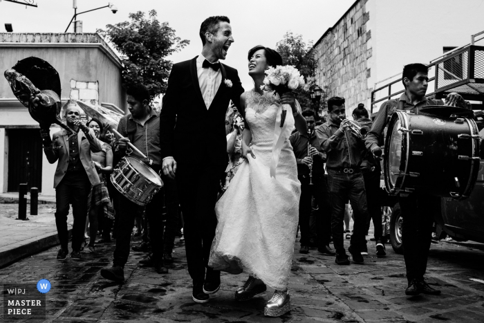 Foto por: <a href="https://www.wpja.com/contests/2018-v10-photography-competition/best-wedding-photographers/2250511"> Nikhol Esteras - Oaxaca de Juárez Oaxaca </a> Foto de boda de Oaxaca, México que muestra a los novios caminando por las calles con músicos.