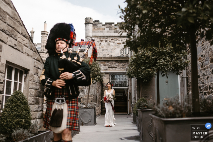 Photo: <a href="https://www.wpja.com/contests/2018-v10-photography-competition/best-wedding-photographers/2250776"> Darren Hendry - Pasadena en Californie </a> La mariée tient son bouquet alors qu'un homme jouant de la cornemuse marche devant elle à Edinbugh, en Écosse, sur cette photo prise par un photographe de mariage de Los Angeles, en Californie.