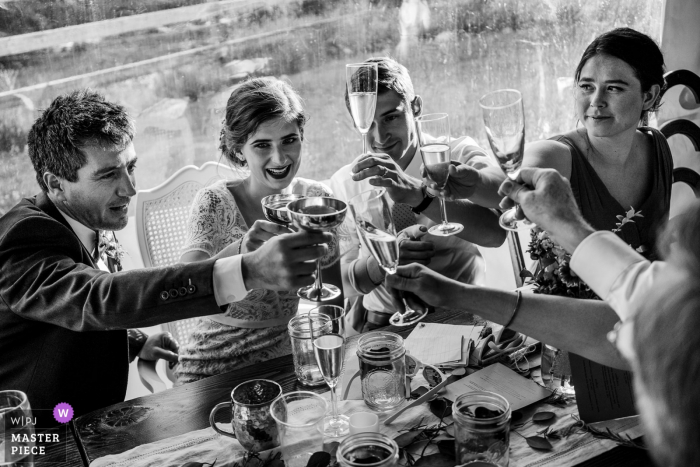 La novia, el novio y los invitados se brindan en esta foto en blanco y negro tomada en Leavenworth, WA, por un fotógrafo de bodas de Seattle.