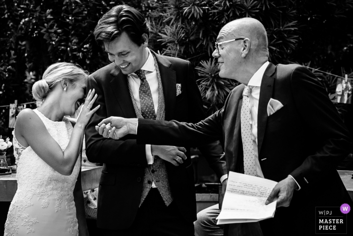 The bride hides her face in the groom's shoulder during the speech in Leiden in this black and white photo by a Netherlands wedding photographer.