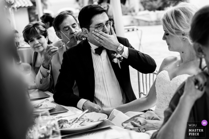 El novio se seca una lágrima de los ojos mientras sostiene la mano de su novia en la Ciudad de México, México, en esta foto en blanco y negro de un fotógrafo de bodas de Rotterdam.