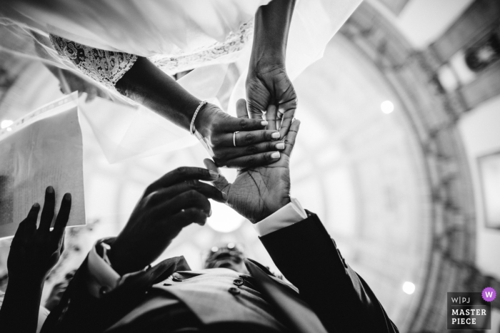 The bride puts the ring on her groom in low angle this black and white photo by a Portugal wedding photographer.