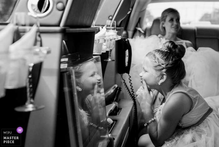 Kennebunkport, Maine wedding photo of flower girl looking at reflection in back of limo.