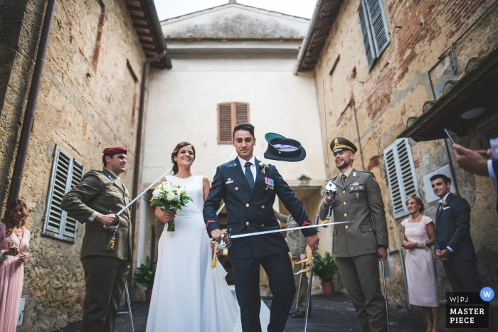 Foto door: <a href="https://www.wpja.com/contests/2018-v11/best-wedding-fotografen/2258606"> Pietro Tonnicodi - Siena Siena </a> Siena bruiloft foto van de bruidegom krijgt zijn hoed verwijderd van zijn hoofd door een zwaard tijdens militaire bruiloft.