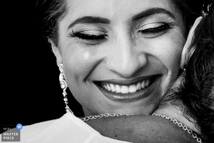 Photo by: <a href="https://www.wpja.com/contests/2018-v11/best-wedding-photographers/2260571">Tunde Koncsol - Budapest</a> Havana, Cuba wedding picture of the bride hugging another woman - tightly cropped photo.