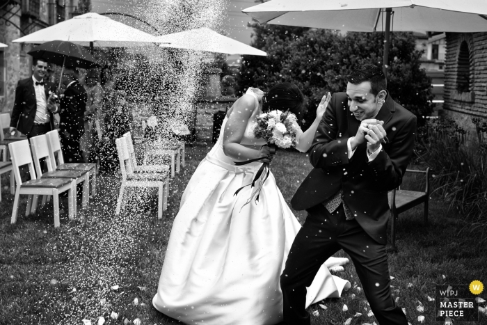 Foto: <a href="https://www.wpja.com/contests/2018-v11-Fotowettbewerb/Best-wedding-Fotografen/2260586"> Monika Zaldo - Zaldibia Guipuzcoa </a> Gipuzkoa-Hochzeitsbild der Braut und des Bräutigams, die versuchen, dem geworfenen Reis zu entgehen.