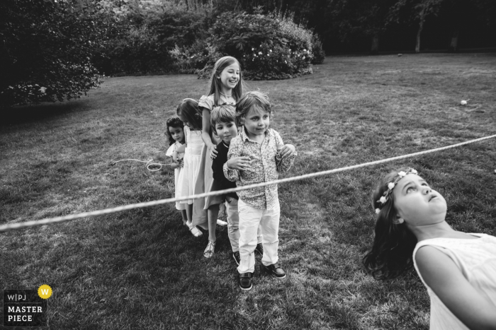 Rouen Wedding Photojournalist | Young children at the wedding reception lineup for limbo games