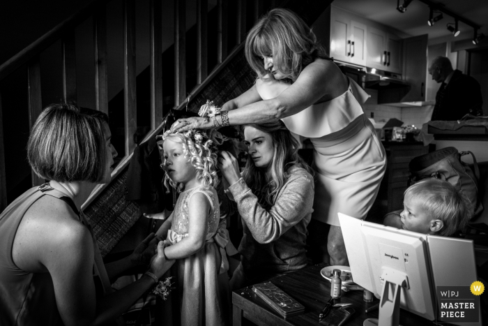 Fotojournalist Alberta Wedding | het jonge bloemenmeisje wordt voorbereid op de ceremonie met bloemen in haar krullende haar