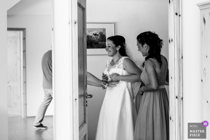 Photo by: <a href="https://www.wpja.com/contests/2018-v11/best-wedding-photographers/2269121">Sabine Schutte-Huneke - Berzhausen Rheinland-Pfalz</a> Nettetal, Germany Wedding Photojournalist | the bride does final checks as she puts on her dress in preparation of the wedding ceremony