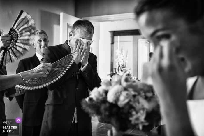 Valencia Wedding Photojournalist | black-and-white photo of family fanning the bride and groom as they cry