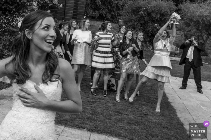Zdjęcie: <a href="https://www.wpja.com/contests/2018-v12/best-wedding-photographers/2272171"> Fabrizio Demasi - Gonzaga Mantova </a> Mantova Wedding Photojournalist | samotna pani łapie bukiet panny młodej na tej recepcji