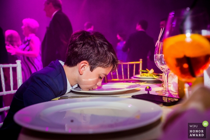 Muchacho joven que limpia su plato de la torta en esta recepción de la boda de Rumania