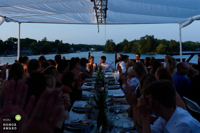 Foto: <a href="https://www.wpja.com/contests/2018-v12-Fotowettbewerb/Best-wedding-Photographier/2277501"> Esther Gibbons - Montreal Quebec </a> Hochzeitspaare belichtet durch Sonnenuntergang am Hochzeitsabendessen in Brockville Ontario