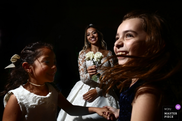 Goiânia Hochzeitsfotojournalist | Die Braut genießt die Zeit mit tanzenden Blumenmädchen