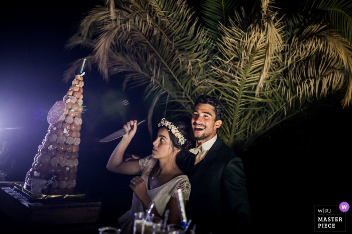 Photo by: <a href="https://www.wpja.com/contests/2018-v13/best-wedding-photographers/2281316">William Lambelet - Montpellier </a> Cutting Cake wedding photography humor with the bride and her knife in Beziers, FRANCE