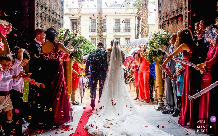 Photo by: <a href="https://www.wpja.com/contests/2018-v13/best-wedding-photographers/2282351">Eduardo Blanco - Águilas Murcia</a> Murcia Wedding Photojournalist | the bride and groom leave the church after the ceremony as guests throw flower petals at them