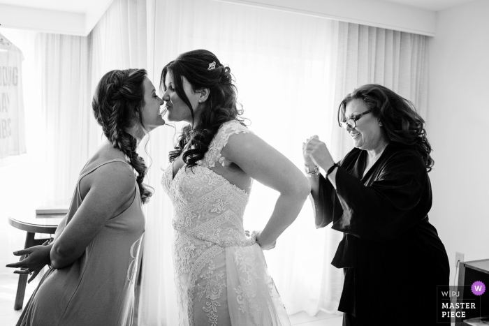 Photo by: <a href="https://www.wpja.com/contests/2018-v13/best-wedding-photographers/2284941">Julie Ambos - Key West Florida</a> Key West Wedding Photojournalist | Florida bride putting on her dress on wedding day