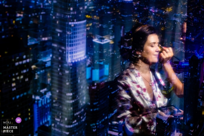 Photo by: <a href="https://www.wpja.com/contests/2018-v13/best-wedding-photographers/2288746">Tunde Koncsol - Budapest</a> Budapest Wedding Photojournalist | Hungary bride having make up applied with City lights behind her