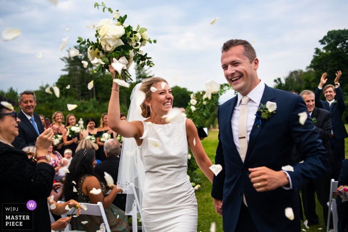 Photo by: <a href="https://www.wpja.com/contests/2018-v13-photography-competition/best-wedding-photographers/2289116">David Murray - Atlanta Georgia</a> The Celebration Begins with flower petals at the end of this Ipswich MA outdoor wedding ceremony