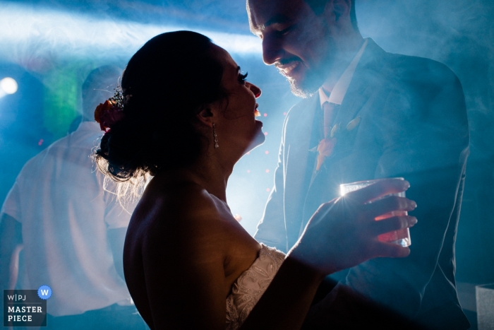 Photo: <a href="https://www.wpja.com/contests/2018-v15/best-wedding-photographers/2305021"> Aline Prado - Macaé Rio de Janeiro </a> Macaé Photojournalist de mariage | Rio de Janeiro mariés dansant avec des boissons sur une piste de danse brumeuse