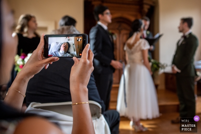 Photo by: <a href="https://www.wpja.com/contests/2018-v15/best-wedding-photographers/2305576">Romulo Morishita - Madison Wisconsin</a> Madison Wedding Photojournalist | Wisconsin indoor wedding ceremony is Broadcast via FaceTime for a family member