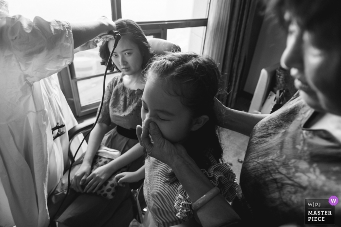 Photo by: <a href="https://www.wpja.com/contests/2018-v15/best-wedding-photographers/2305676">Micky Zhou - Xiangtan </a> Hunan Wedding Photojournalist | China bride having her hair curled before the actual wedding ceremony