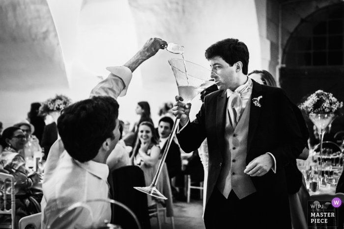 Photo by: <a href="https://www.wpja.com/contests/2018-v15/best-wedding-photographers/2305931">Ronan Jégaden - Athis-Mons </a> Bourgogne - France Wedding Photojournalist | the groom drinks from a very large Champagne glass at Île-de-France wedding reception
