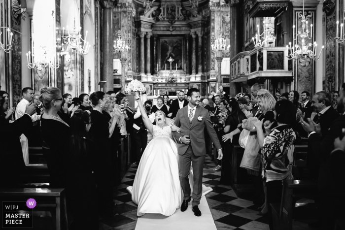 Photo by: <a href="https://www.wpja.com/contests/2018-v15/best-wedding-photographers/2309396">Julian Kanz - Portofino Genova</a> Genoa bride leave the church with the groom as a guest steps on her veil - portofino wedding photographer