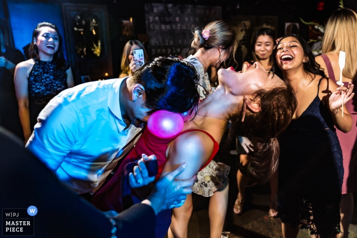 Photo by: <a href="https://www.wpja.com/contests/2018-v15/best-wedding-photographers/2311076">Yun Li - Setauket New York</a> Paper Factory Hotel, New York wedding photograph of guests trying to pop balloons on the dance floor