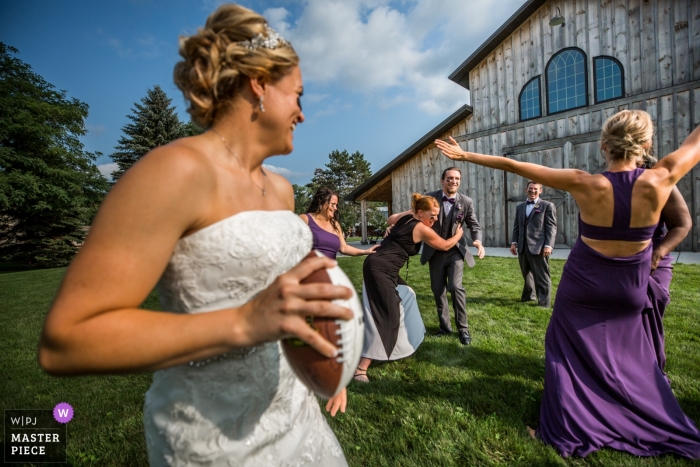 Photo by: <a href="https://www.wpja.com/contests/2018-v15/best-wedding-photographers/2313761">Earl McCoy - Columbia Heights Minnesota</a> bride playing football | Quarterback Bride| Minneapolis Minnesota