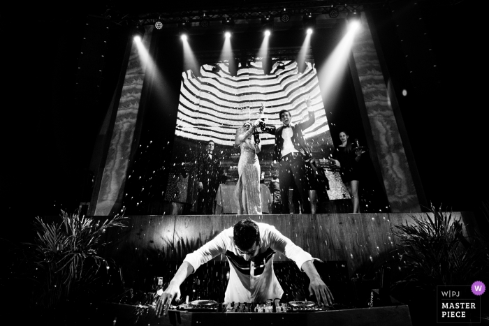 Photo by: <a href="https://www.wpja.com/contests/2018-v15/best-wedding-photographers/2316206">Ankita Asthana - Mumbai Maharashtra</a> Wedding shoot with Doha couple blasting champagne over the DJ who is trying to cover his boards in Qatar