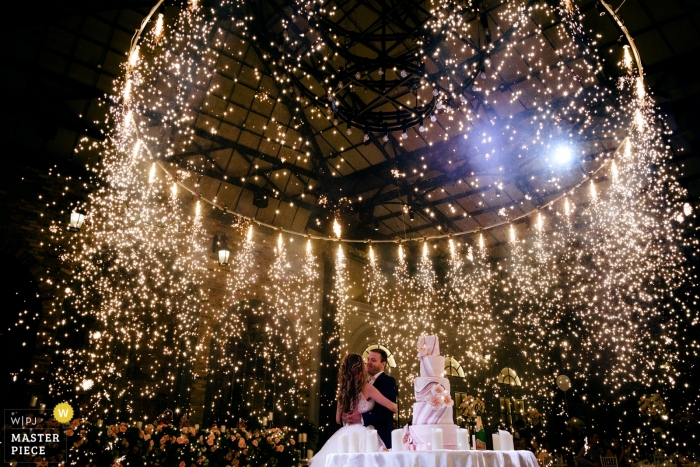 Ein armenisches Paar während der Zeremonie zum Anschneiden der Hochzeitstorte unter einem Funkenfeuerwerk